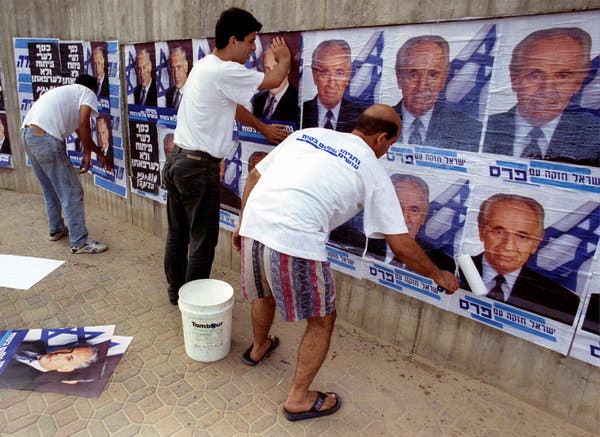 Các nhà hoạt động cánh hữu dán áp
phích tranh cử cho ông Netanyahu đè lên áp phích tranh cử của Thủ
tướng Shimon Peres vào tháng 5-1996, trước cuộc bầu cử sẽ đưa ông
Netanyahu lên nắm quyền. Ảnh: Reuters