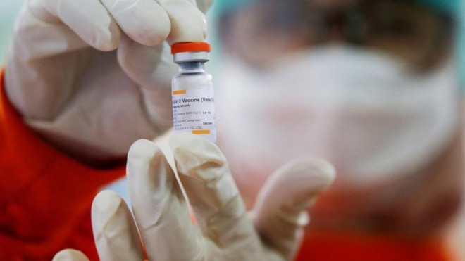 Nhân viên y tế đang cầm một lọ vaccine ngừa COVID-19. Ảnh: SOUTH CHINA MORNING POST