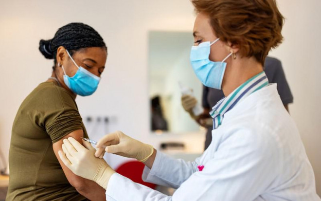 Một người phụ nữ gốc Phi được tiêm vaccine ngừa COVID-19. Ảnh: GOOGLE