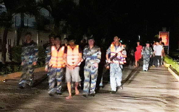 Nguyễn Minh Động (x) được dẫn giải từ tàu cảnh sát biển về cơ quan điều tra