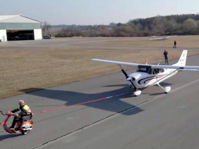 Xe máy - Xe đạp - Vespa một bánh kéo máy bay trên đường băng