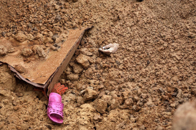 Một thi thể chôn trong mộ tập thể ở Bucha ngày 2-4. Ảnh: Reuters