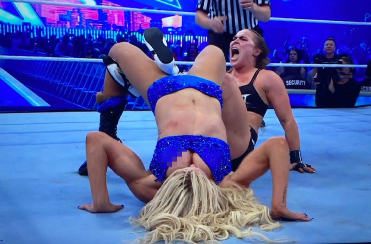 Rousey (phải) khiến Flair (áo xanh) lộ "vòng 1" khi đang thi đấu