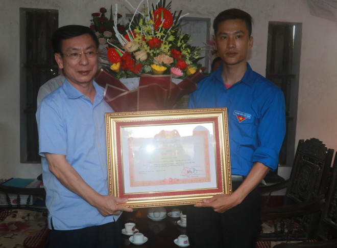 Chủ tịch UBND tỉnh Nam Định Phạm Đình Nghị trao bằng khen của Thủ tướng Chính phủ cho anh Nguyễn Đức Chính, người đã dũng cảm lao xuống sông cứu nữ sinh lớp 8