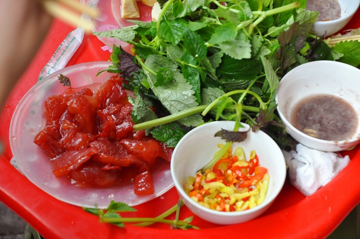 “Con sứa là màu trắng nhưng khi đánh bắt lên sẽ được ngâm với muối và quả vẹt để khử tanh và có màu đỏ bắt mắt. Khi ăn sẽ cắt thành từng miếng vừa ăn, kèm với cùi dừa cắt miếng, lá tía tô, kinh giới, đậu nướng rồi chấm với mắm tôm”, bà Lập nói.
