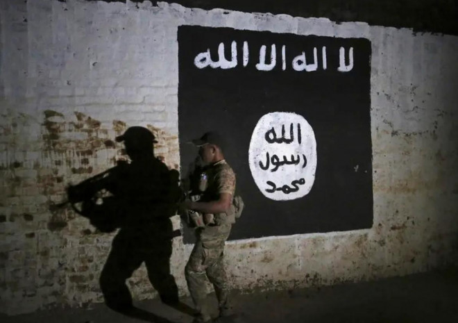 Một binh sĩ Iraq kiểm tra đường hầm xe lửa mới được phát hiện gần đây, có treo cờ của nhóm khủng bố IS. Ảnh: AP&nbsp;