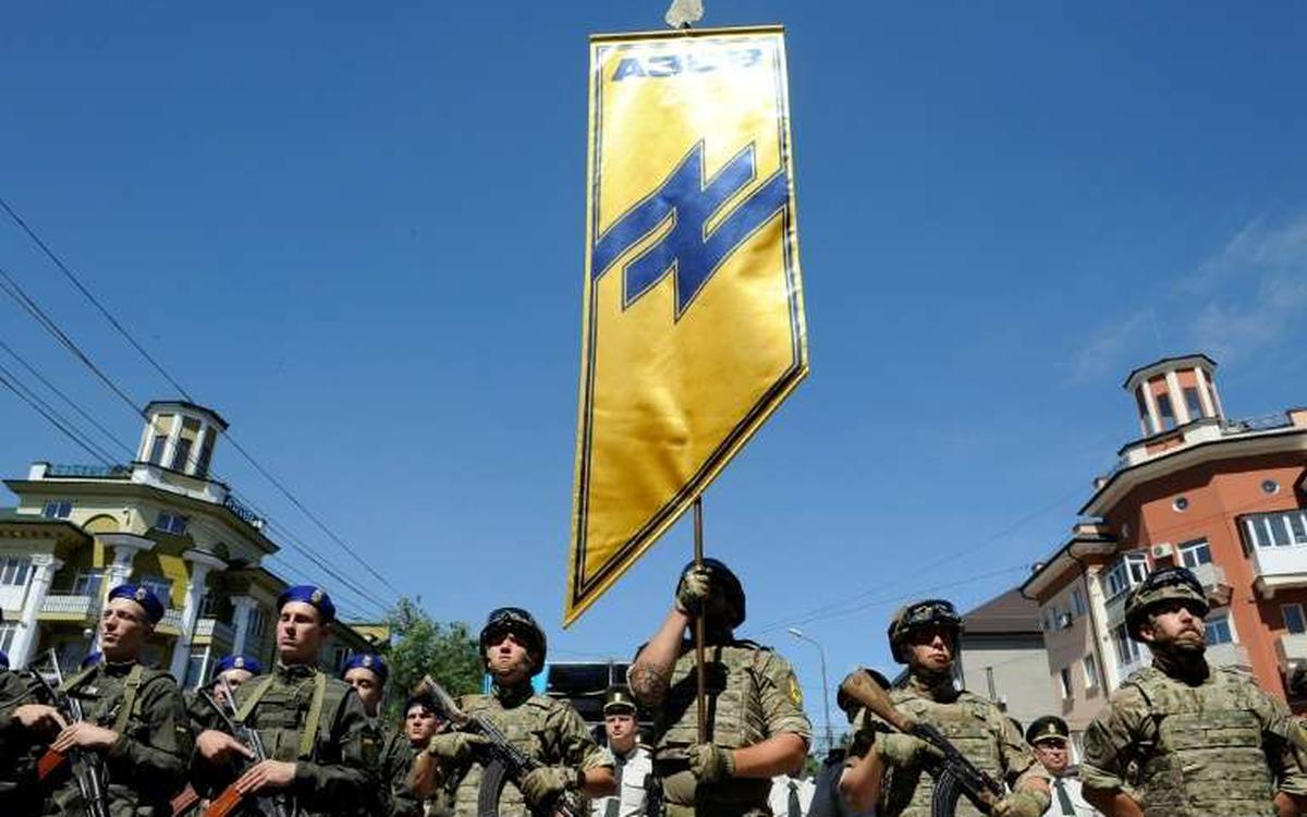 Chiến binh Azov cùng lá cờ mang biểu tượng “Wolfsangel” (ảnh: AP)