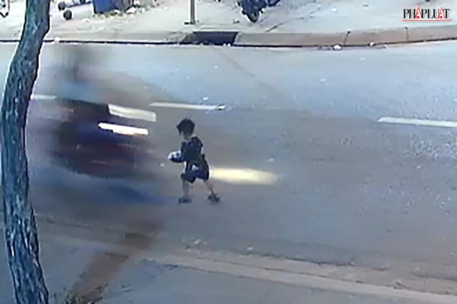Bé trai băng qua đường để nhặt bóng thì bị xe máy tông trúng. Ảnh chụp từ clip