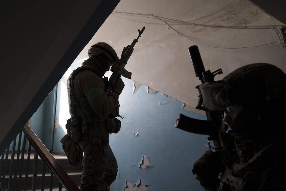 Lực lượng SBU của Ukraine với súng lắp giảm thanh đột kích một căn nhà nghi có người làm “gián điệp” cho quân đội Nga (ảnh: AP)