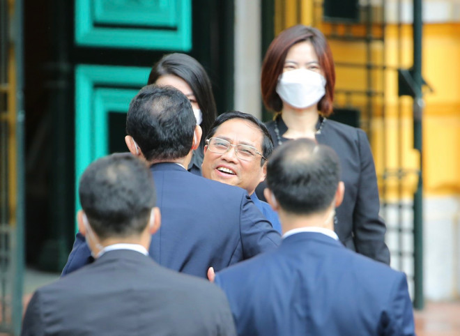 Thủ tướng Phạm Minh Chính đón Thủ tướng Nhật Bản Kishida Fumio tại cửa xe ôtô. Ảnh: Hữu Hưng