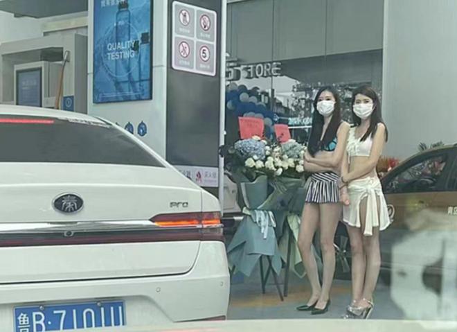 Hai cô gái tiếp thị trạm xăng ở Thanh Đảo, Trung Quốc ngày 26/4.