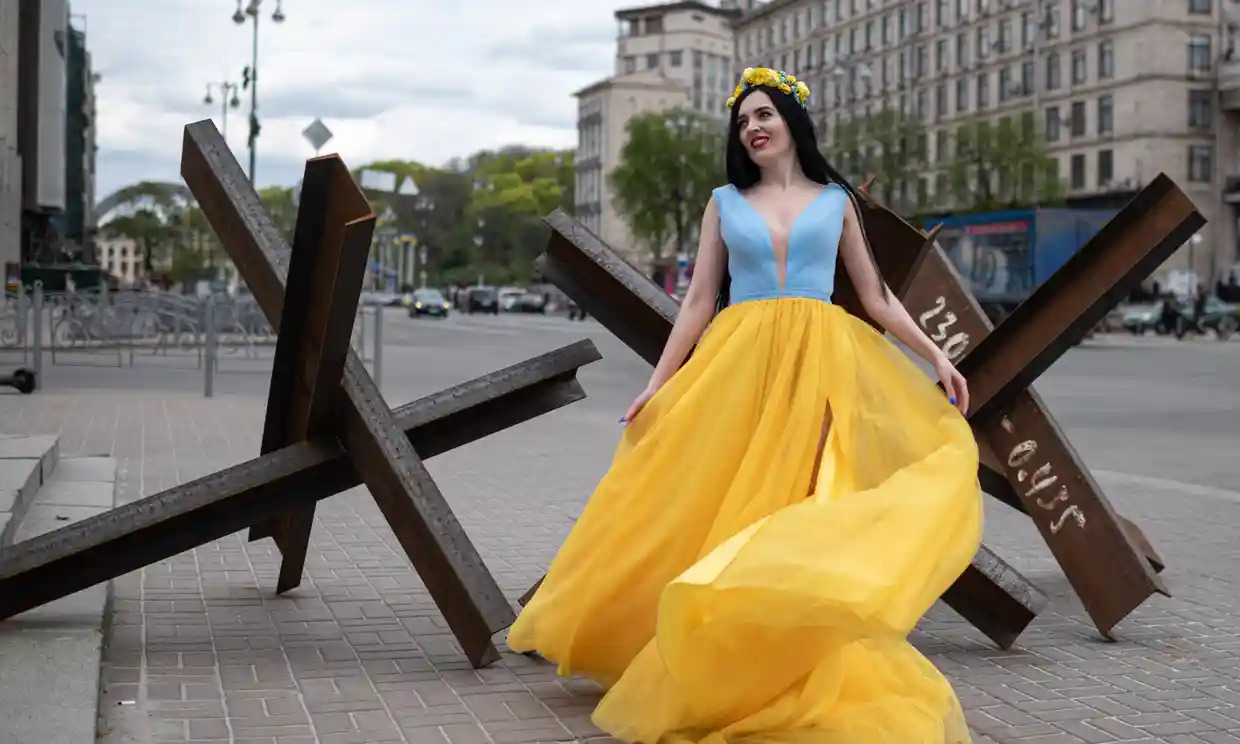 Một cô gái Nga mặc váy màu xanh – vàng ở Kiev sau khi lực lượng Nga chuyển lực lượng về Donbass (ảnh: CNN)