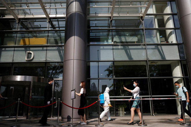 Người đi làm quét mã QR trước khi vào một tòa nhà văn phòng ở thủ đô Bắc Kinh - Trung Quốc hôm 5-5 Ảnh: Reuters