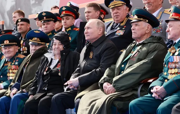 Ông Putin sau đó ngồi xem diễu binh cùng các khách mời. Ảnh: Reuters