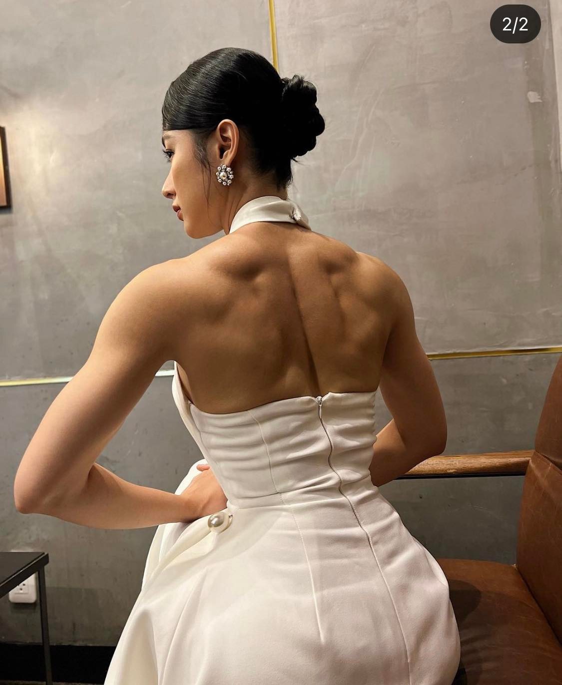 Angela Phương Trinh diện váy nữ tính đối lập với hình ảnh cơ bắp cuồn cuộn, bị nhận xét làm mất đi vẻ đẹp nữ tính vốn có.