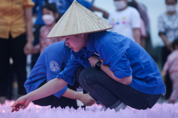 Các tình nguyện viên thắp hoa đăng, chuẩn bị cho buổi lễ.