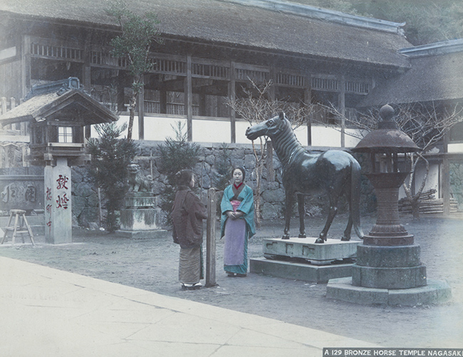 Hai người phụ nữ trong trang phục truyền thống của Nhật đang trò chuyện tại Đền Ngựa Đồng Nagasaki. 
