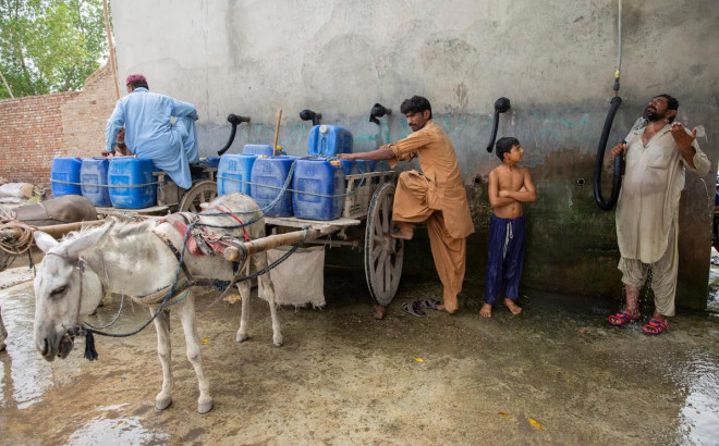 Người dân Jacobabad làm mát thông qua nguồn cung nước uống (can màu xanh) lẫn nước sinh hoạt hạn chế. (Ảnh chụp năm 2021). Ảnh: TELEGRAPH