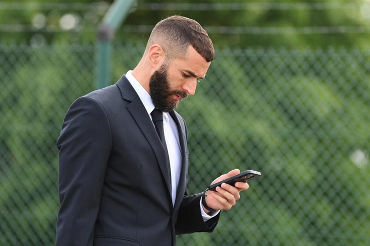Karim Benzema vừa đi vừa xem điện thoại
