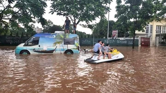 Đường phố ngập sâu, ô tô, xe máy không thể di chuyển, cư dân tại phố Mễ Trì lấy mô-tô nước ra đưa đón người thân