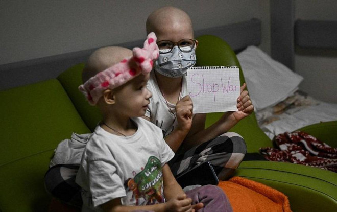 Những trẻ em mắc bệnh ung thư cầm biểu ngữ kêu gọi "Dừng chiến tranh" trong một hầm trú bom của một bệnh viện ở Thủ đó Kiev, Ukraine.