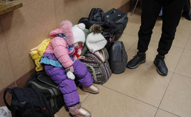 Một đứa trẻ mệt mỏi sau hành trình dài từ Ukraine đến thành phố Rzeszow Glowny, Ba Lan.