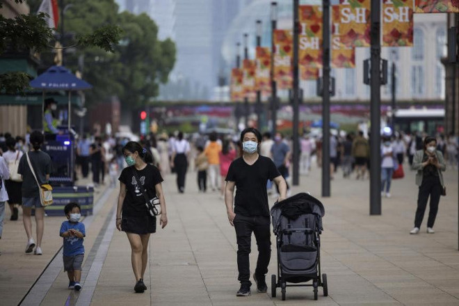 Người dân đi dạo trên đường phố trong ngày đầu tiên nới lỏng các hạn chế ở Thượng Hải hôm 1-6. Ảnh: EPA-EFE