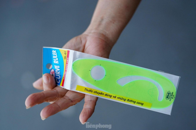 Một giáo viên chuẩn bị đồ dùng chuyên toán, đứng đợi với phụ huynh trước cổng. "Chuẩn bị hết, các con cần gì là chúng tôi đáp ứng ngay. Tất cả chỉ để các con toàn tâm cho việc thi cử", cô giáo dạy Toán Phạm Thị Minh Thu, trường THCS Hà Huy Tập tâm sự.