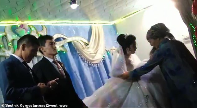 Cô dâu được hai người phụ nữ dìu khỏi sân khấu với sự vô cảm của chú rể