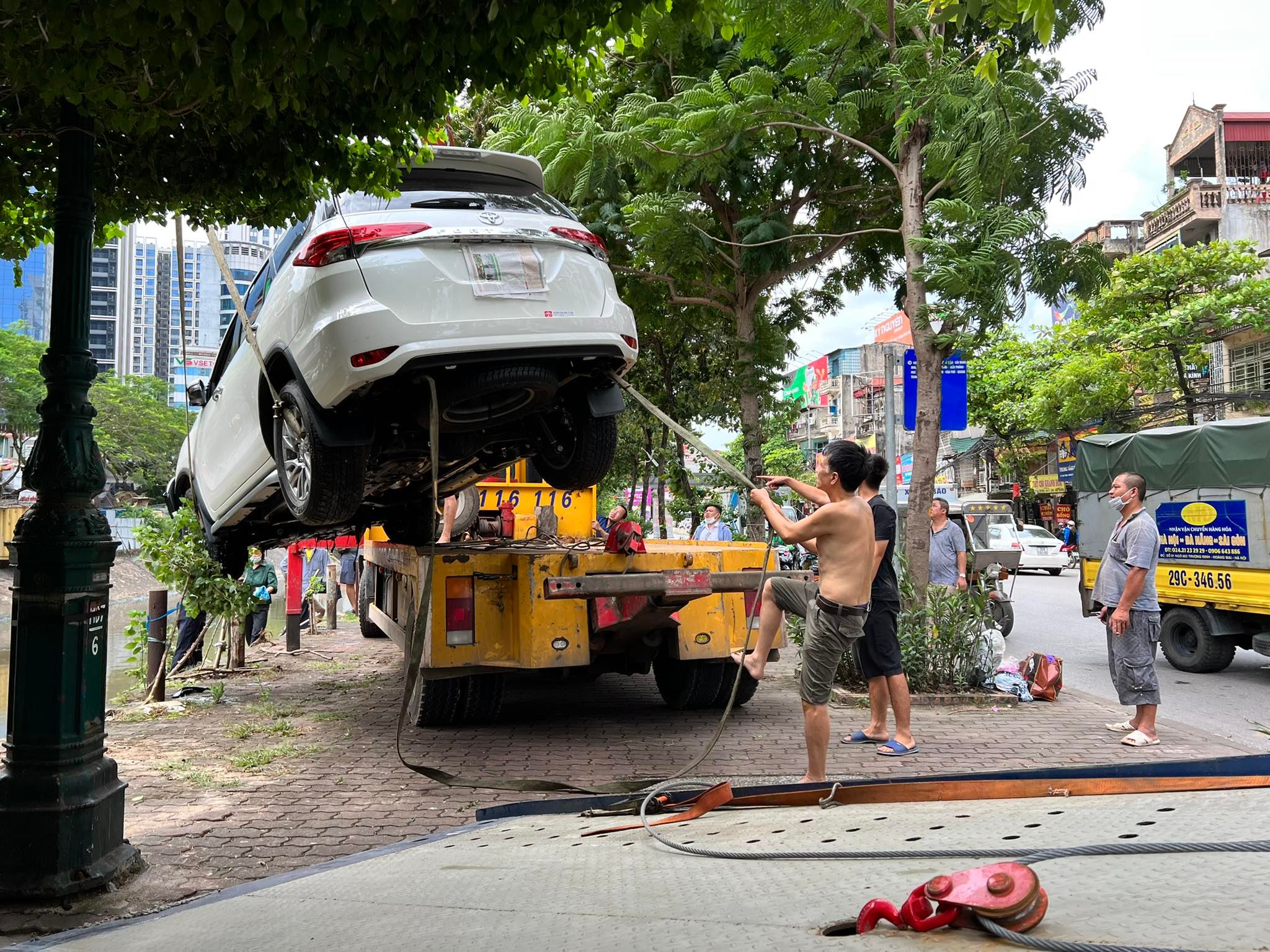 Đội cứu hộ cùng chủ phương tiện và người dân&nbsp;cẩu xe. Sau khoảng 30 phút, chiếc xe được cẩu thành công lên bờ.