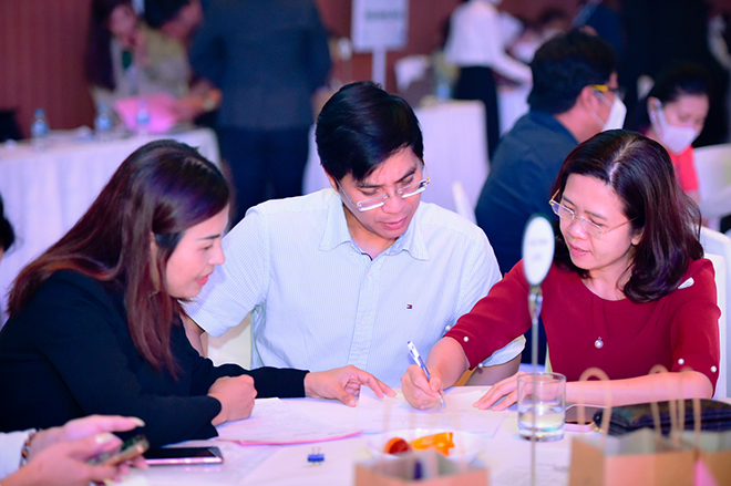 Đội ngũ nhân viên kinh doanh cung cấp thông tin đến khách hàng tham dự sự kiện