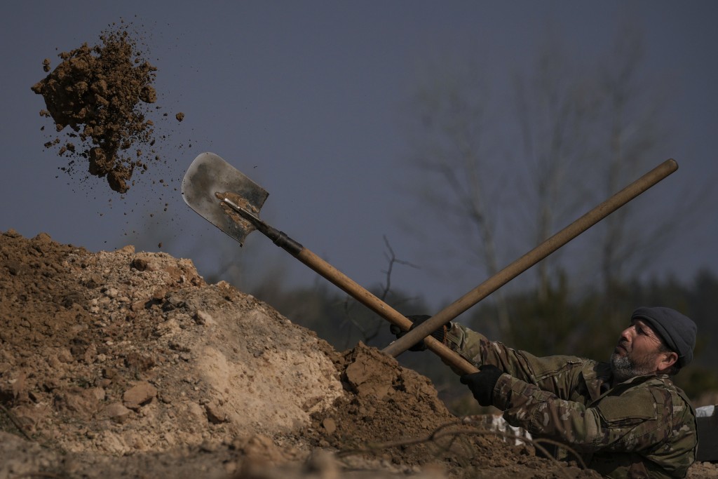 Một binh sĩ Ukraine đang dùng xẻng đào công sự chiến đấu (ảnh: AP)