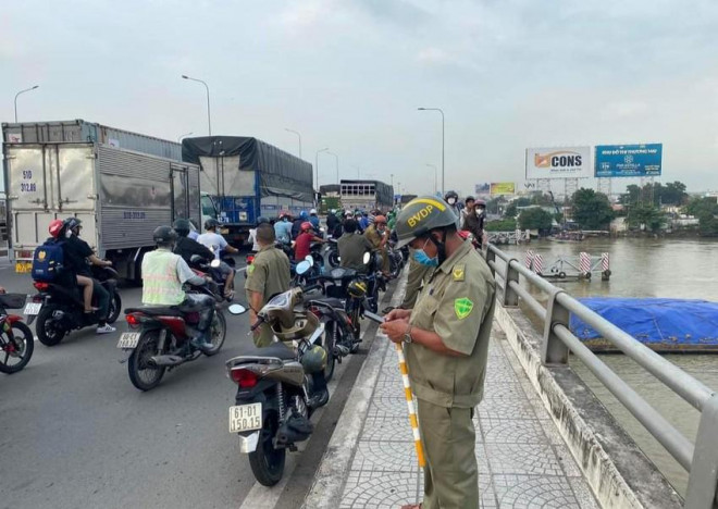 Lực lượng chức năng có mặt trên cầu Đồng Nai để điều tiết giao thông vì người hiếu kỳ dừng lại xem rất đông. Ảnh: VH.