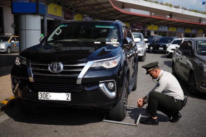 Xe ô tô vi phạm bị lực lượng chức năng khóa bánh. Ảnh: B.HÀ