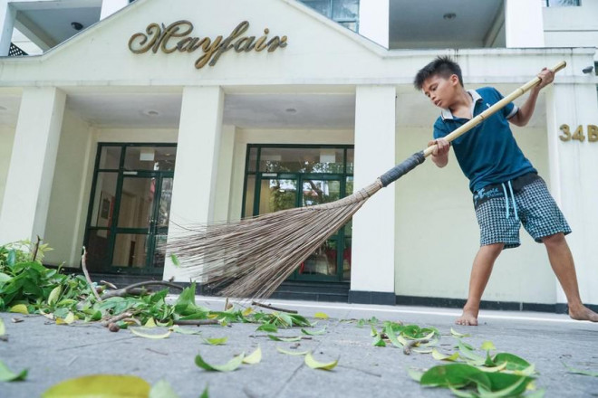 Thu hoạch xong, Huy cẩn thận phụ cha quét dọn trả lại không gian sạch sẽ cho vỉa hè Hà Nội.