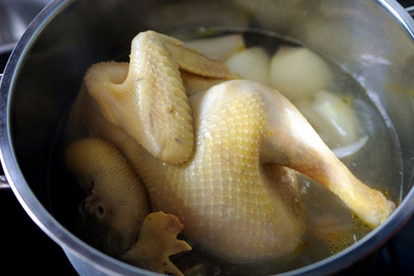 Luộc gà với gừng nướng cho thơm. Ảnh: Hà Ly