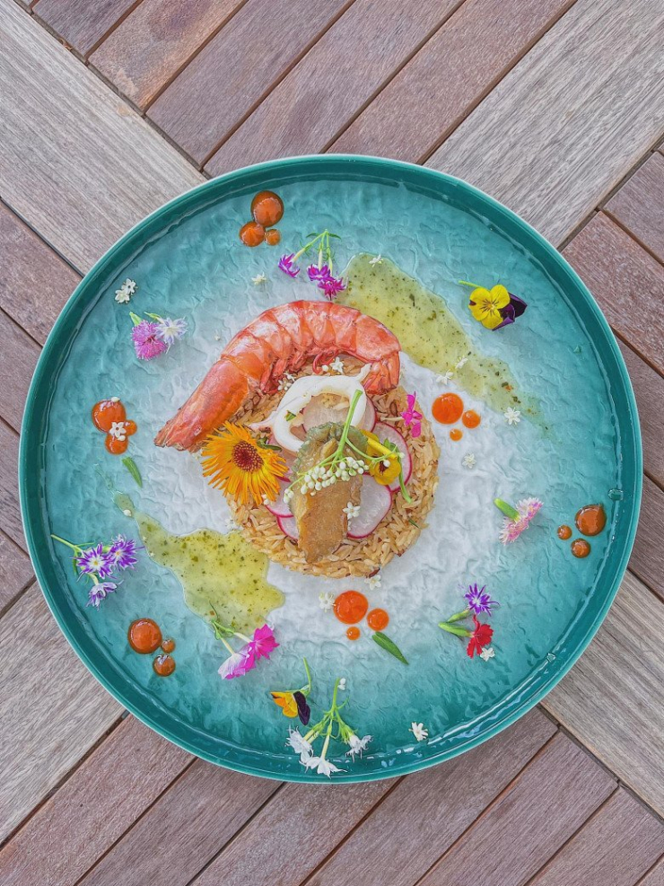 Món cơm chiên hải sản với cơm và tôm tạo hình trái tim xinh xắn, được tô điểm hoa lá xung quanh. Những giọt tương ớt cũng tạo thành nét chấm phá thú vị.