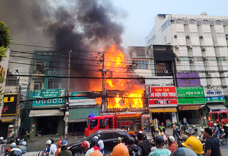 Ngọn lửa bùng lên dữ dội, lan sang cửa hàng bán phụ tùng ô tô. Ảnh: M.L