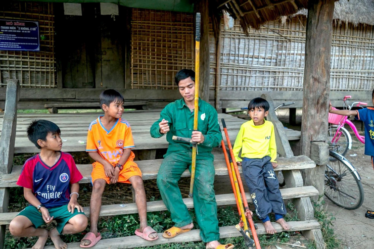Anh Tham hướng dẫn các em nhỏ trong làng cột, sử dụng cà kheo