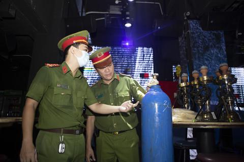 Trung tá Nguyễn Hữu Nam Phong (bên phải) đang kiểm tra số lượng vỏ bóng và bình khí N2O nghi sử dụng làm khí cười