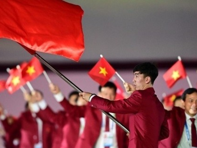 Kình ngư Nguyễn Huy Hoàng cầm cờ cho đoàn thể thao Việt Nam tại khai mạc SEA Games 32