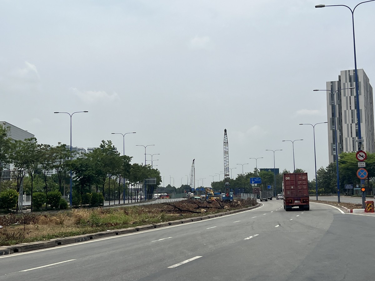 Đơn vị thi công đang di dời cây xanh, khoan thí nghiệm ở nút giao An Phú. Ảnh: ĐÀO TRANG
