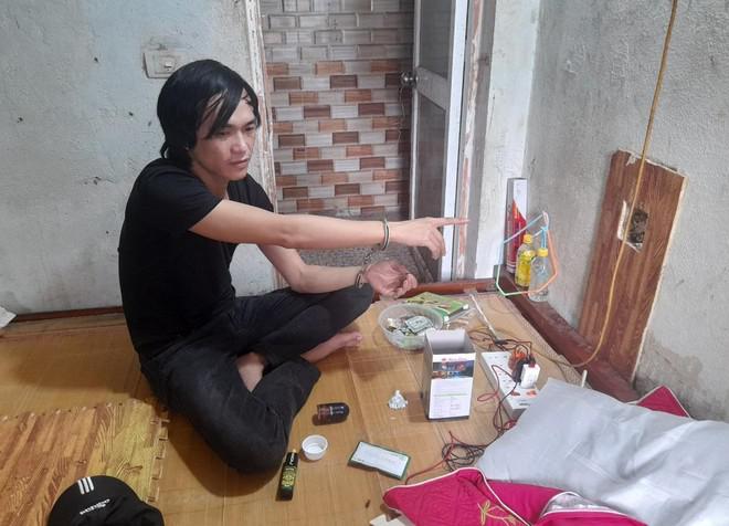 Đối tượng Sơn ngồi trong phòng bán ma tuý qua lỗ đục trên bức tường