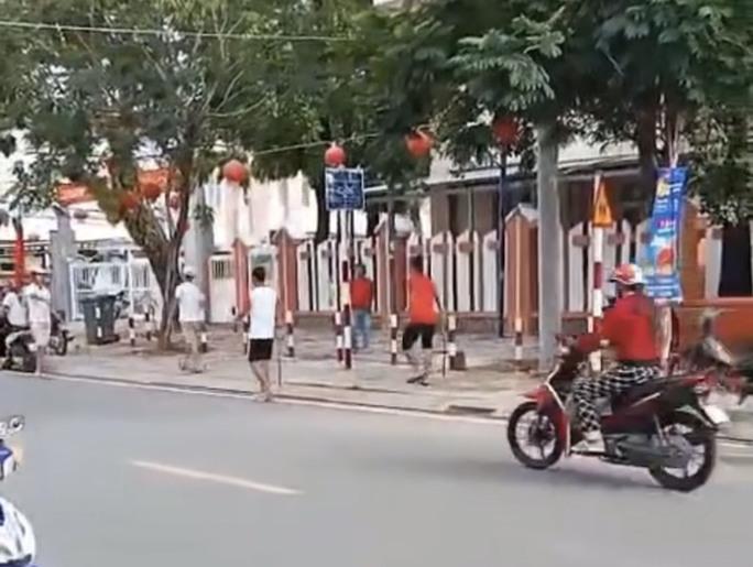 Nhóm người cầm hung khí chuẩn bị vào trụ sở UBND xã Hàm Ninh (Ảnh: cắt từ clip)