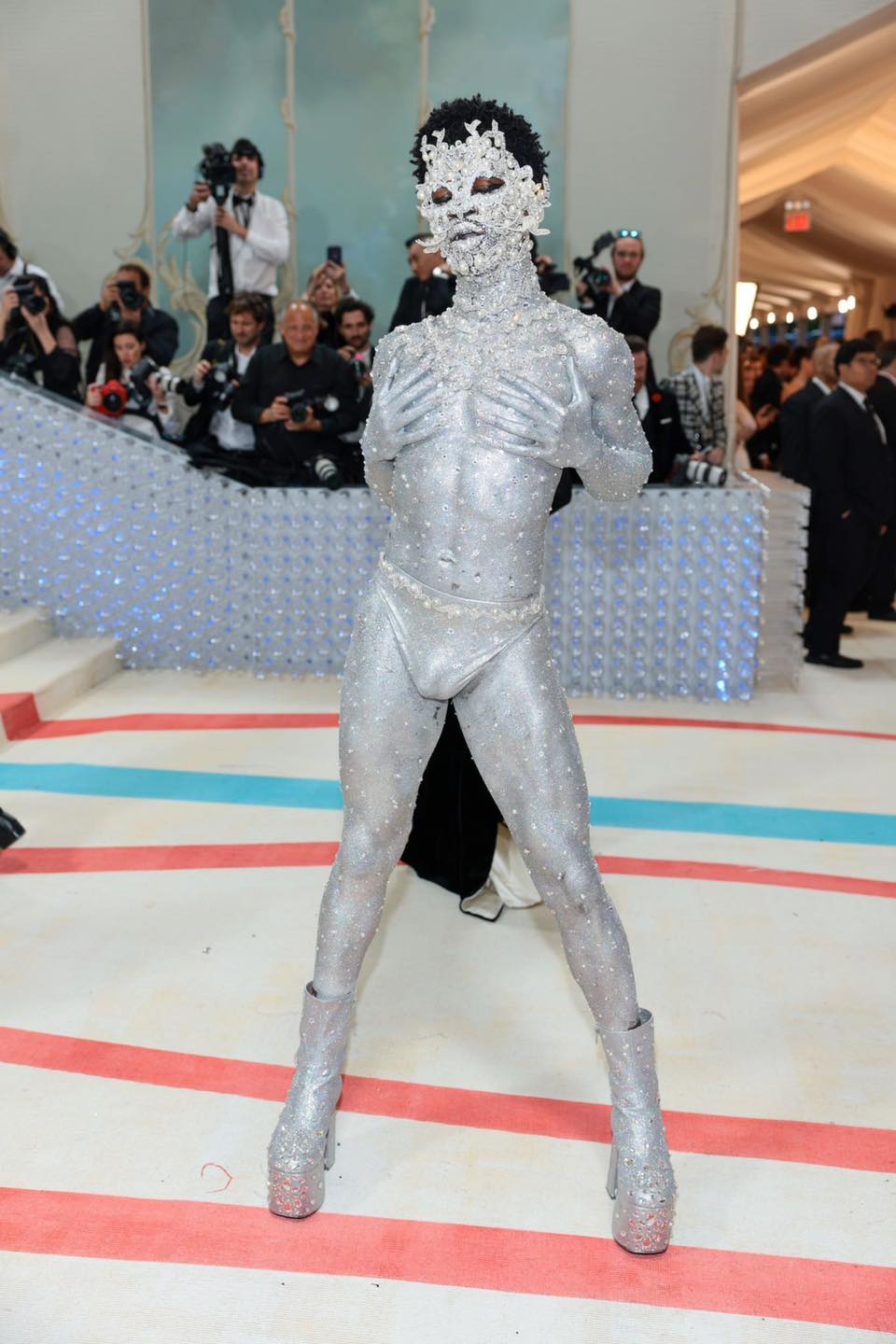 Lil Nas X xuất hiện trên thảm đỏ Met Gala 2023 với diện mạo độc đáo. Rapper phủ kín metallic, kim cương, đá quý và ngọc trai lên cơ thể. Anh diện duy nhất nội y ánh bạc, để lộ toàn bộ cơ thể săn chắc dưới lớp sơn metallic.&nbsp;