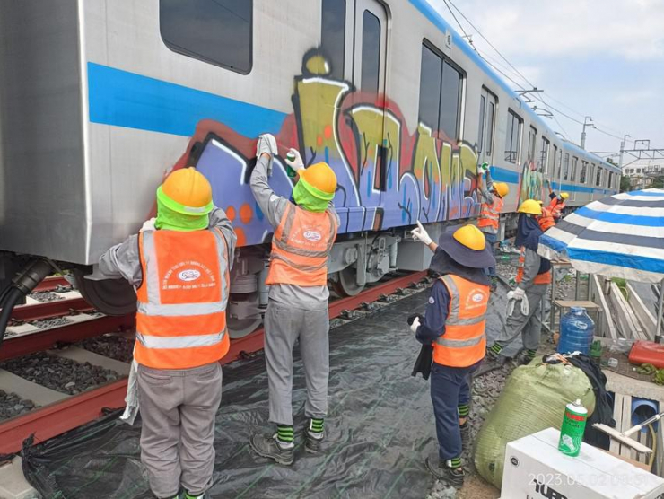 Các công nhân tẩy rửa, sơn lại tàu metro số 1. Ảnh: MAUR