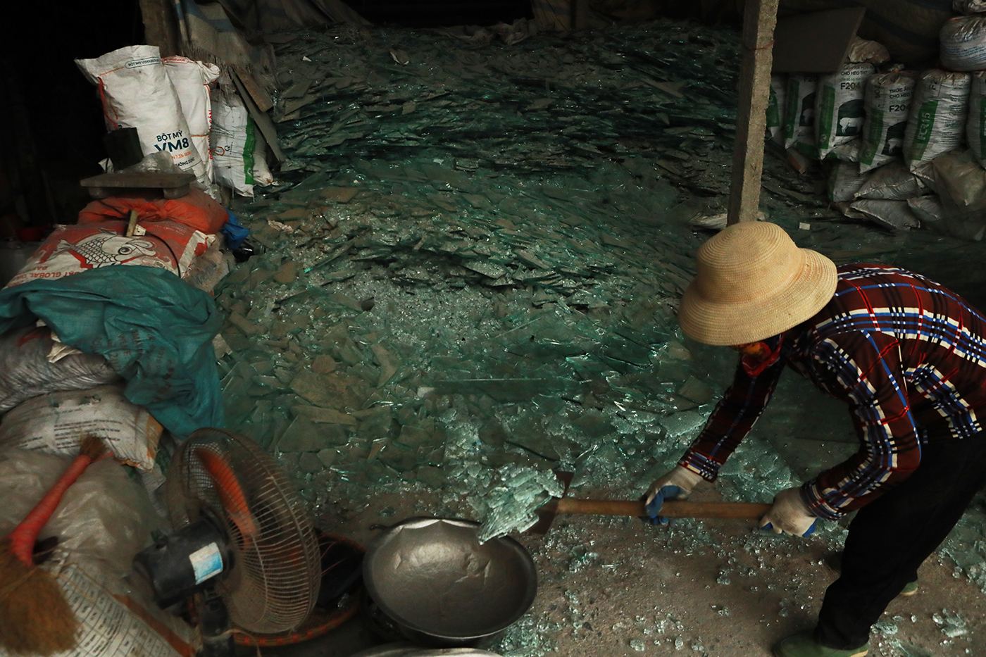 Thủy tinh nguyên liệu sau khi thu gom được các phụ nữ trong làng nghề sơ chế, đập vỡ trước khi đưa vào lò nung chảy.