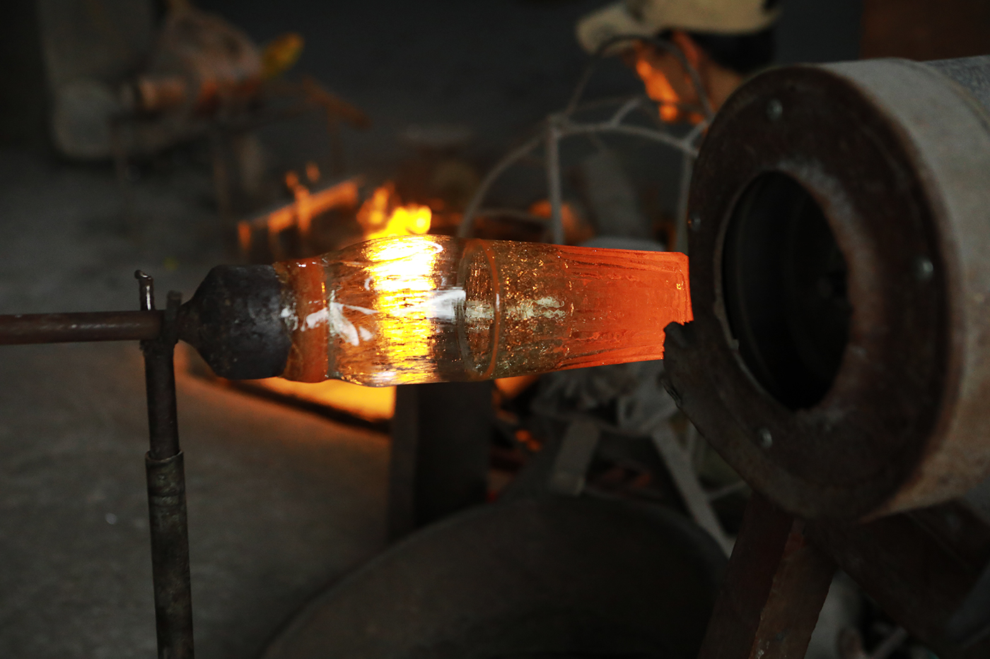 Sau khi thổi định hình, những cục thủy tinh nóng chảy đã ra hình chiếc cốc.