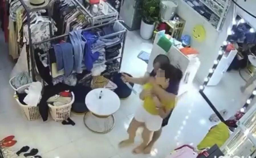 Nữ chủ shop quần áo bị người đàn ông cầm dao uy hiếp. Ảnh: Chụp từ clip.