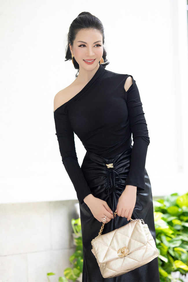 Set đồ đen tuyền nhưng không hề già nua vì được chủ nhân tinh tế mix cùng túi xách tay và khuyên tai ánh kim. Chiếc áo lệch vai với chi tiết cut-out lạ mắt cùng phần chun rút mới mẻ ở chân váy giúp diện mạo nữ diễn viên “Tình khúc Bạch Dương” trở nên sành điệu, thời trang đồng thời vẫn tối giản, hợp đi làm.